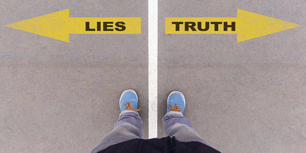 Lies vs truth text on yellow arrows on asphalt ground, feet and shoes on floor, personal perspective footsie concept