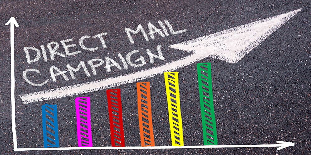 DIRECT MAIL CAMPAIGN written with chalk on tarmac over colorful graph and rising arrow, business marketing and creativity concept