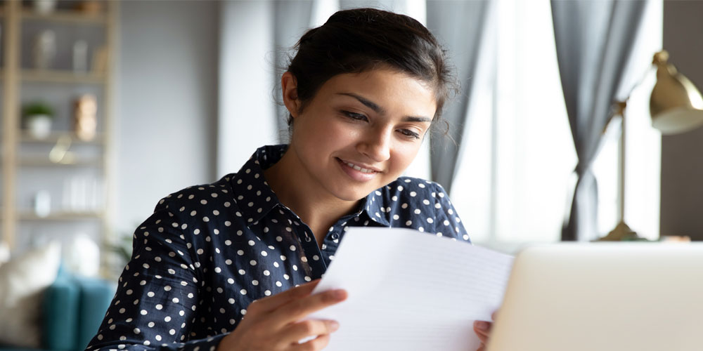 Image of woman reading mail at home.