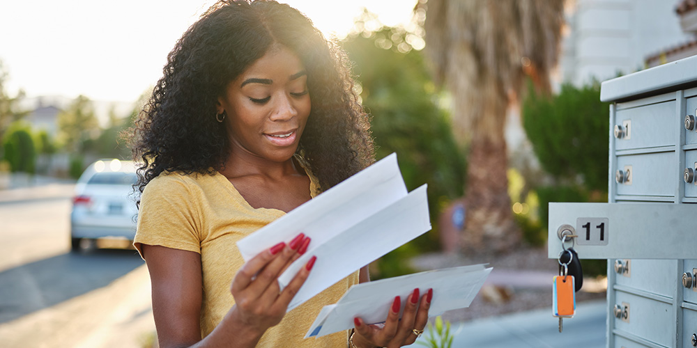 Smiling woman opening mail