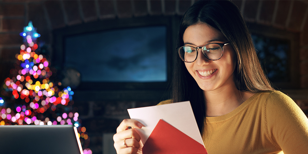Woman opening a piece of holiday direct mail